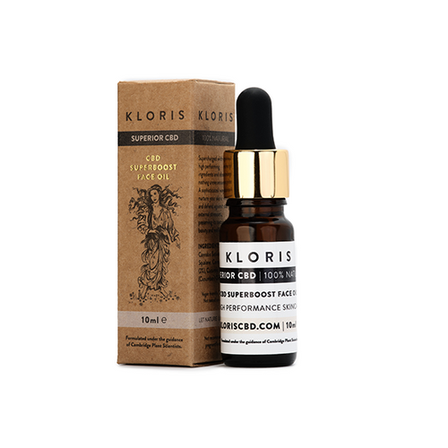 A 10ml bottle of Kloris 2% CBD Superboost Face Oil, perfect for redness-prone skin, is positioned next to its brown cardboard box packaging. The vegan bottle features a black dropper cap and a white label with black text. The packaging includes black text and an intricate line drawing.