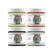 Load image into Gallery viewer, A set of four Lady Green Hemp Infused Candles, with two green and two orange products, are arranged in a two-by-two grid. Each jar sports a white label featuring a vintage illustration of a woman in a green headscarf under the brand name &quot;Lady Green.&quot; The decorative lace patterns on the labels emphasize that these candles are made from organic soy wax and hemp oil.
