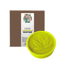 Load image into Gallery viewer, The image shows a round, yellow-green soap bar with a hemp leaf design on top, labeled &quot;Lady Green Hemp Soap Bar&quot; from the brand Green Apron. Behind the soap is a brown box with a label featuring an illustration of a woman holding a plant, and product information beneath—perfect for those who love the zest of limoncello.
