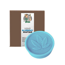 Load image into Gallery viewer, A round, light blue soap bar embossed with a hemp leaf sits in front of a brown packaging box. The label on the box reads &quot;Lady Green Hemp Soap Bar&quot; by Green Apron and features an illustration of a person holding a plant intertwined with sugarcane.
