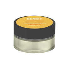 Load image into Gallery viewer, A small, round container with a black lid labeled &quot;Sensi Skin&quot; on top with &quot;100mg CBD Sugar Lip Scrub,&quot; and &quot;Honey&quot; beneath it on a yellow background. The transparent container reveals the vegan-friendly lip scrub inside.
